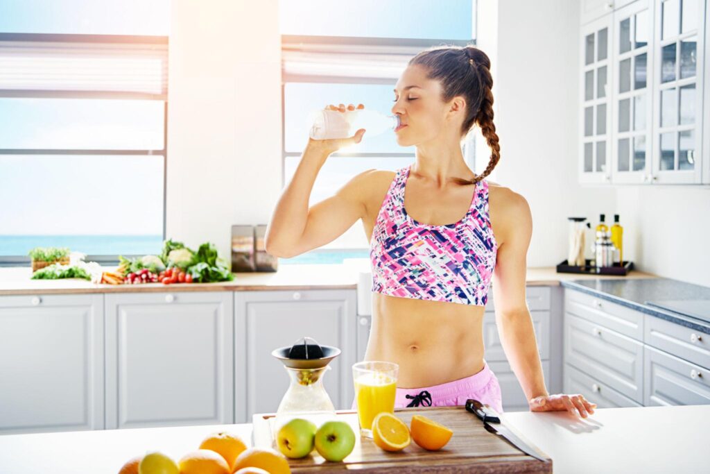 Woman drinking water to support weight loss, hydration, appetite control, and a healthy metabolism.